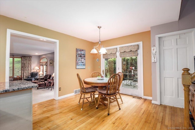 dining room with light wood-style flooring, baseboards, and healthy amount of natural light