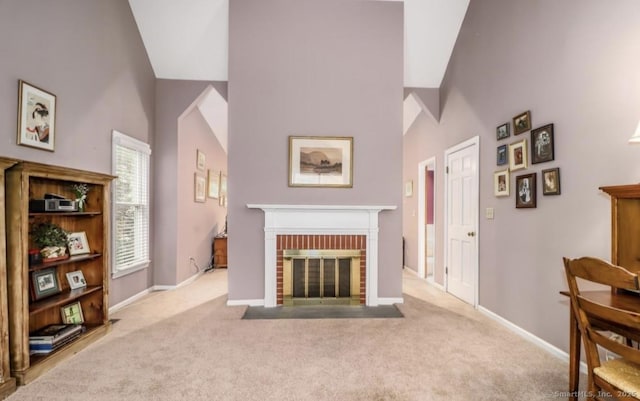 living area featuring a towering ceiling, a fireplace, carpet floors, and baseboards