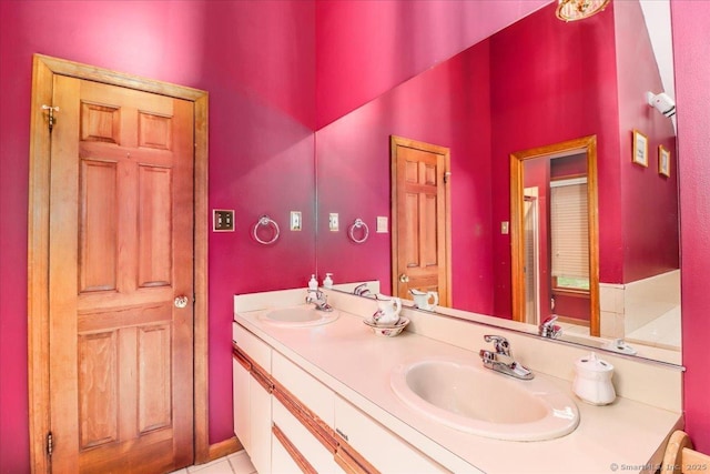 bathroom with double vanity, a shower with door, and tile patterned flooring