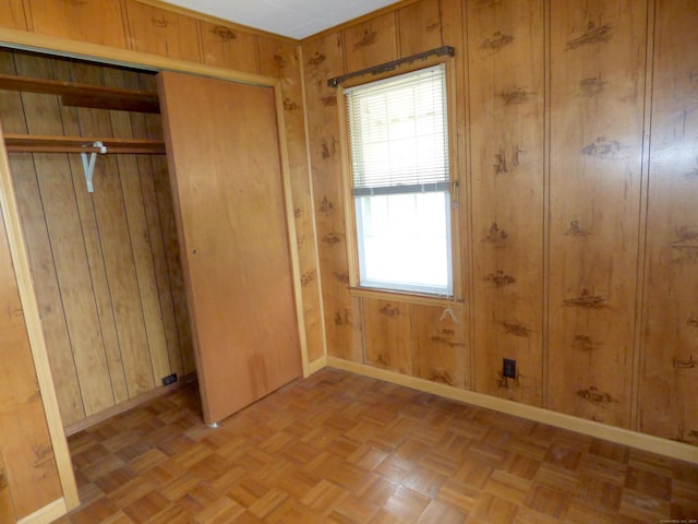 992 Ridge Rd, Wethersfield, CT 06109 - unfurnished bedroom with baseboards, wooden walls, and a closet
