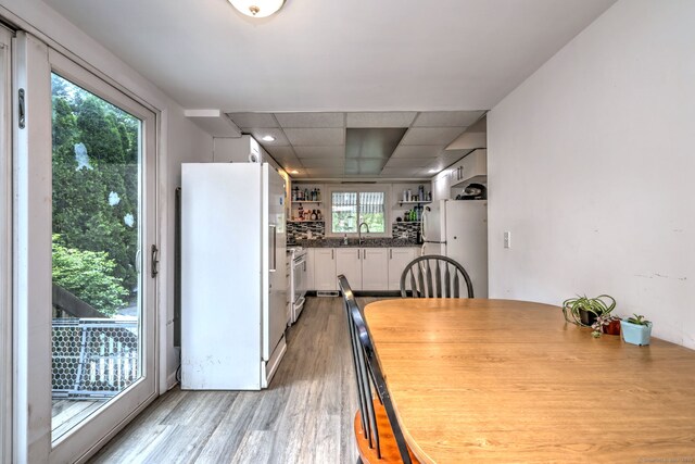 53 Harwinton Ave Apt 1, Torrington, CT 06790 - kitchen with white appliances, light wood finished floors, white cabinetry, dark countertops, and a sink