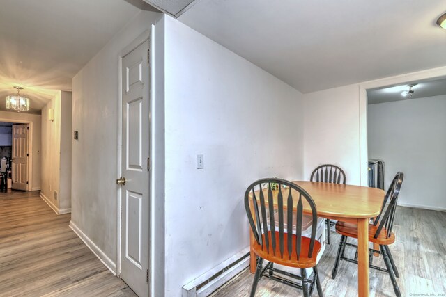 53 Harwinton Ave Apt 1, Torrington, CT 06790 - dining room featuring a baseboard heating unit, light wood-style floors, baseboards, and a chandelier
