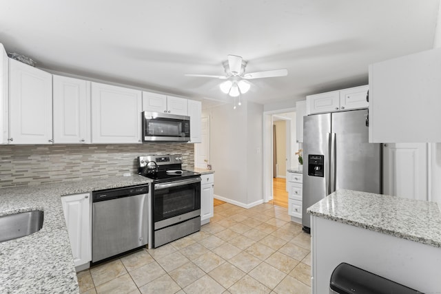 315 Prospect St, Wethersfield, CT 06109 - kitchen with appliances with stainless steel finishes, backsplash, white cabinetry, and light tile patterned floors