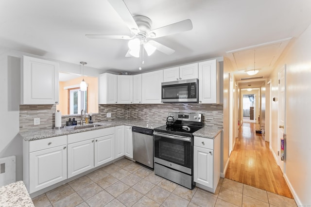 315 Prospect St, Wethersfield, CT 06109 - kitchen featuring appliances with stainless steel finishes, a sink, decorative backsplash, and white cabinetry