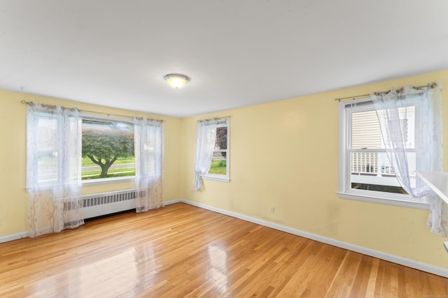 315 Prospect St, Wethersfield, CT 06109 - empty room featuring radiator, baseboards, healthy amount of natural light, and wood finished floors