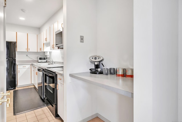 42 Temple Ct Unit 42, New Haven, CT 06511 - kitchen with black appliances, a sink, white cabinets, light countertops, and light tile patterned flooring