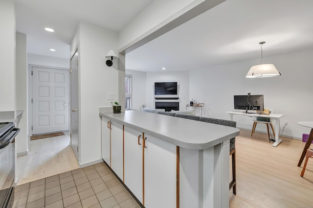 42 Temple Ct Unit 42, New Haven, CT 06511 - kitchen featuring white cabinets, electric range, a peninsula, light wood-style floors, and recessed lighting