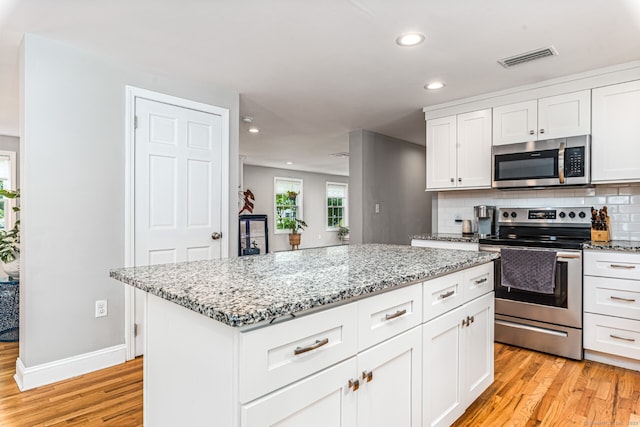 57 Harvard Ct, Middletown, CT 06457 - kitchen with stainless steel appliances, light wood finished floors, recessed lighting, light stone counters, and white cabinets