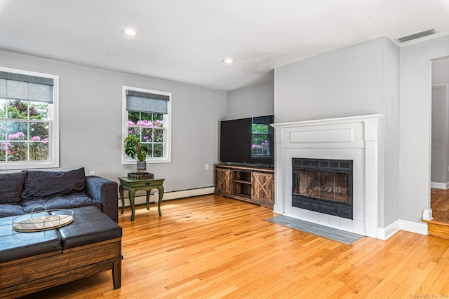 57 Harvard Ct, Middletown, CT 06457 - living room featuring light wood-type flooring, a tiled fireplace, recessed lighting, a baseboard heating unit, and baseboards