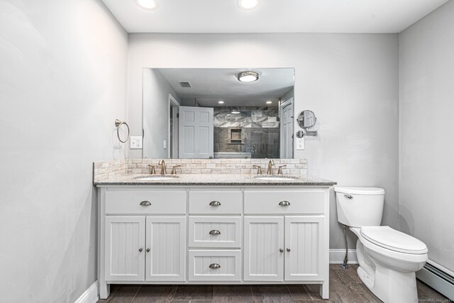 57 Harvard Ct, Middletown, CT 06457 - full bathroom featuring a baseboard radiator, baseboards, double vanity, toilet, and tiled shower