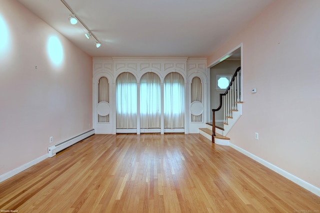 145 Casmir Dr, Fairfield, CT 06825 - unfurnished room with baseboard heating, light wood finished floors, stairway, and rail lighting