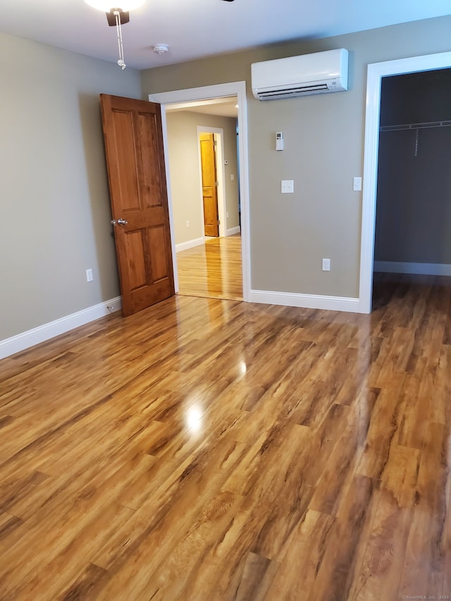 47 Mckinley Ave, Bristol, CT 06010 - empty room featuring a wall mounted air conditioner, light wood finished floors, baseboards, and ceiling fan