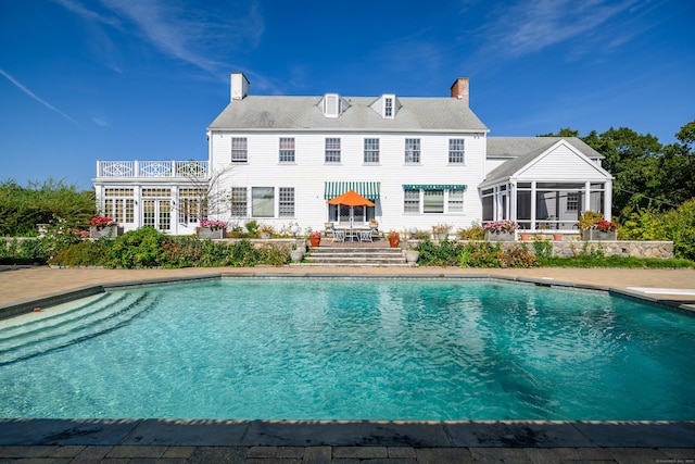 49 Great Ring Rd, Newtown, CT 06482 - back of house featuring a sunroom, an outdoor pool, a chimney, and a balcony