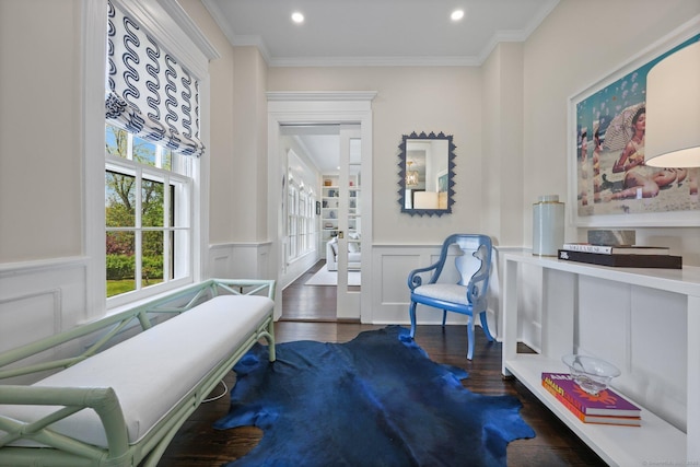 living area with wainscoting, recessed lighting, wood finished floors, ornamental molding, and a decorative wall