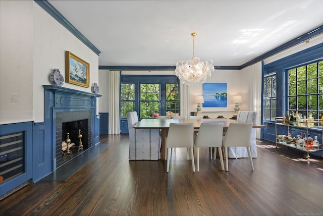 dining space with ornamental molding, a chandelier, beverage cooler, dark wood-style floors, and a fireplace