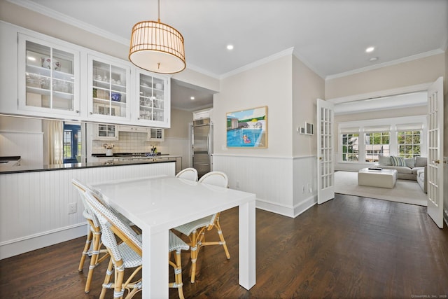 dining space featuring dark wood finished floors, wainscoting, crown molding, and recessed lighting