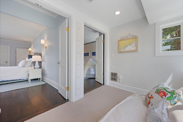 bedroom featuring wood finished floors, baseboards, and recessed lighting