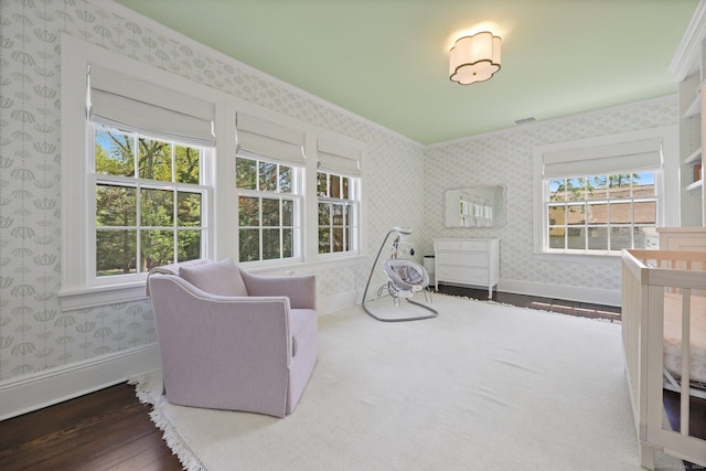 bedroom featuring wallpapered walls, wood finished floors, baseboards, and ornamental molding