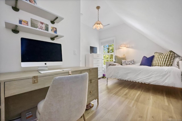 bedroom with lofted ceiling and light wood finished floors