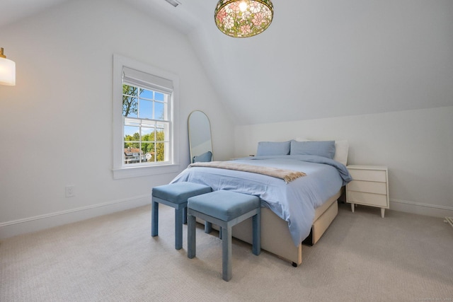 bedroom with vaulted ceiling, light colored carpet, and baseboards