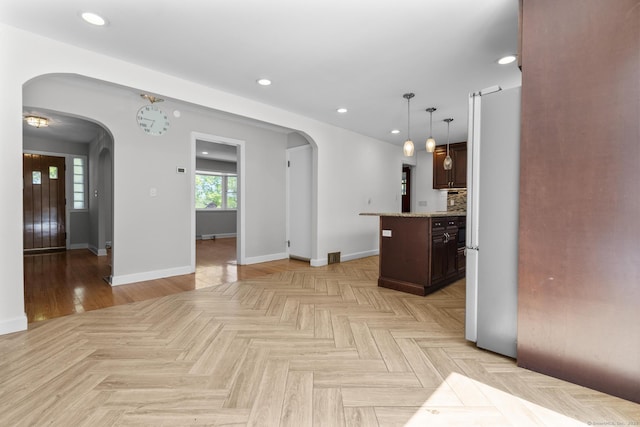 130 Fitch St, North Haven, CT 06473 - kitchen with arched walkways, baseboards, dark brown cabinetry, freestanding refrigerator, and recessed lighting