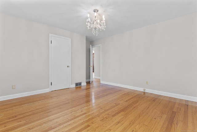 130 Fitch St, North Haven, CT 06473 - unfurnished room with a chandelier, light wood-style floors, and baseboards