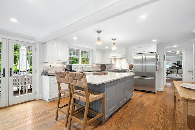 135 Limekiln Rd, Redding, CT 06896 - kitchen with appliances with stainless steel finishes, crown molding, tasteful backsplash, white cabinets, and a kitchen island
