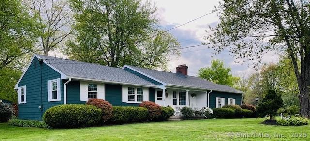ranch-style house featuring a front yard and a chimney