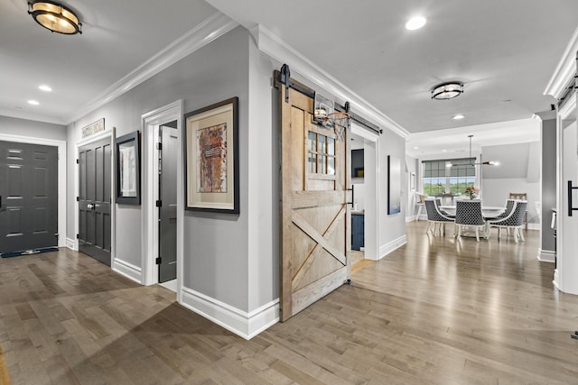 66 High St Unit 40, Guilford, CT 06437 - hallway with a barn door, crown molding, baseboards, recessed lighting, and wood finished floors