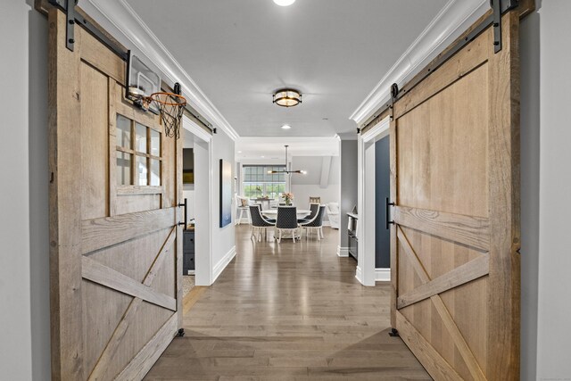 66 High St Unit 40, Guilford, CT 06437 - corridor featuring a barn door, ornamental molding, wood finished floors, and baseboards