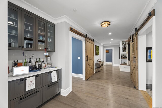 66 High St Unit 40, Guilford, CT 06437 - bar area featuring a barn door, crown molding, light wood-style floors, baseboards, and recessed lighting