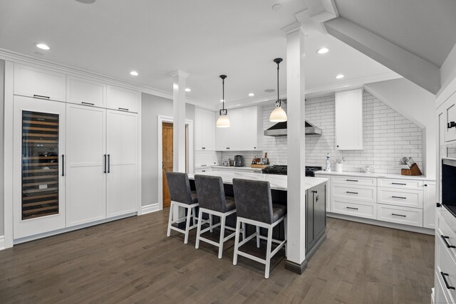 66 High St Unit 40, Guilford, CT 06437 - kitchen with beverage cooler, backsplash, white cabinetry, a kitchen island, and recessed lighting