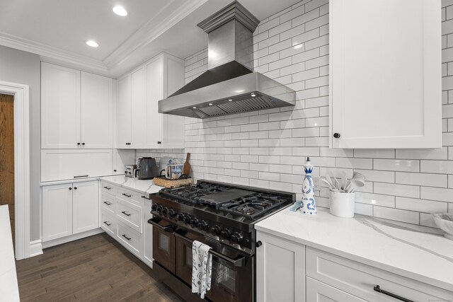 66 High St Unit 40, Guilford, CT 06437 - kitchen with wall chimney exhaust hood, double oven range, crown molding, white cabinets, and backsplash