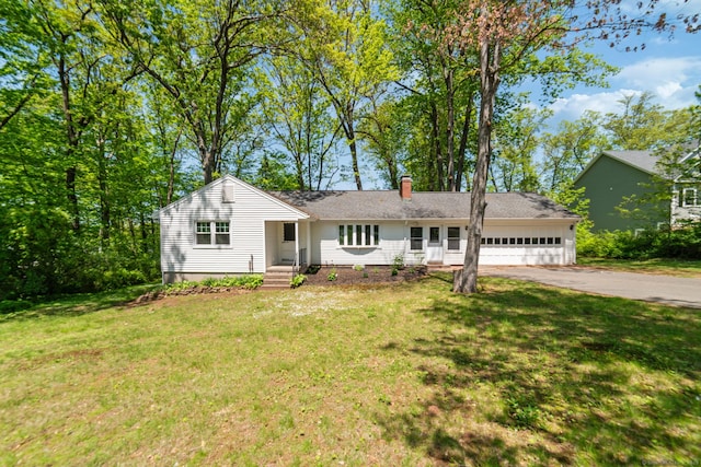 ranch-style house with driveway, an attached garage, and a front yard