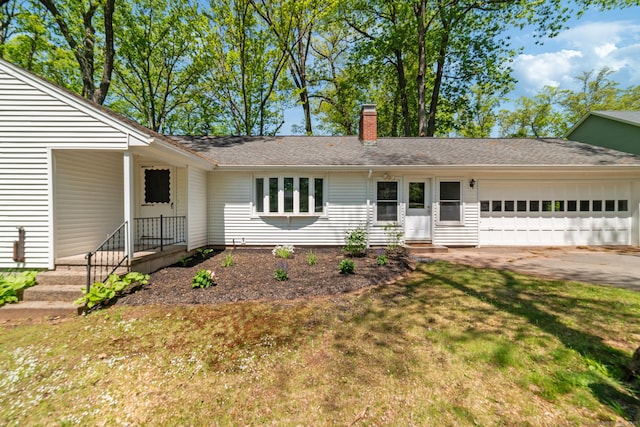 single story home with an attached garage, a chimney, concrete driveway, and a front yard