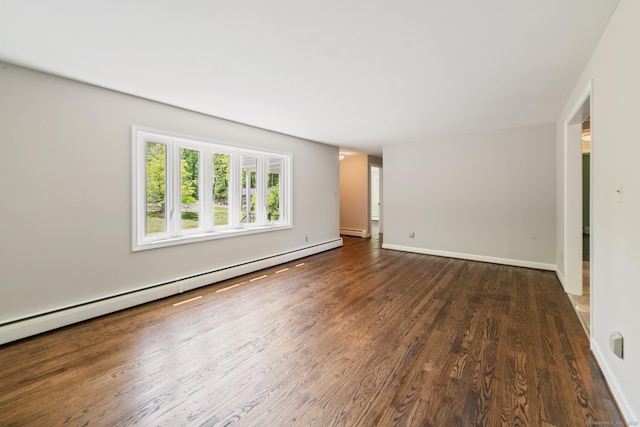 unfurnished living room featuring a baseboard heating unit, wood finished floors, and baseboards