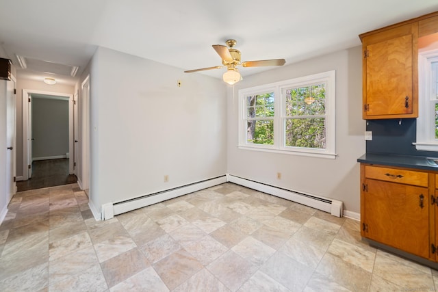 unfurnished dining area with a baseboard heating unit, baseboards, and stone finish flooring