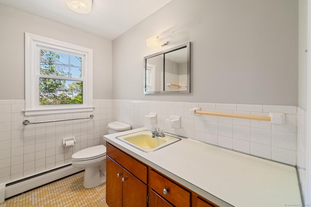 bathroom with baseboard heating, tile walls, a wainscoted wall, tile patterned floors, and toilet
