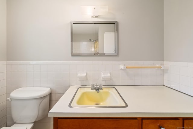bathroom featuring vanity, toilet, and wainscoting