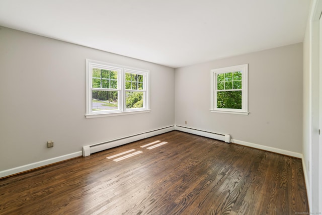 spare room with a baseboard radiator, wood finished floors, and baseboards