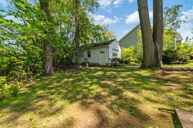 view of grassy yard with an outdoor structure