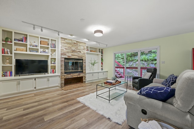 114 Mountain View Rd, Glastonbury, CT 06033 - living room featuring rail lighting, light wood finished floors, a fireplace, and built in shelves