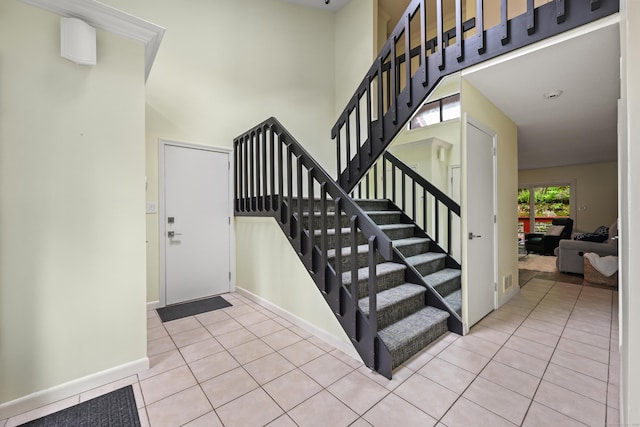 114 Mountain View Rd, Glastonbury, CT 06033 - stairway with a towering ceiling, tile patterned flooring, and baseboards