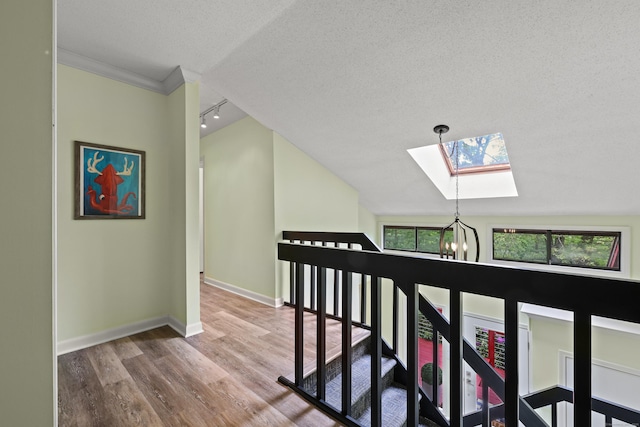 114 Mountain View Rd, Glastonbury, CT 06033 - hall featuring a skylight, a textured ceiling, a chandelier, wood finished floors, and baseboards