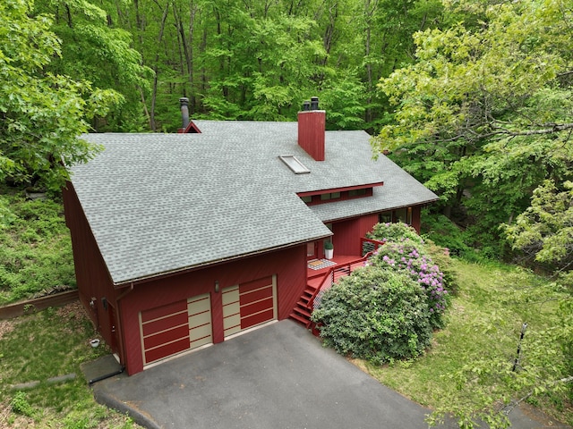 114 Mountain View Rd, Glastonbury, CT 06033 - view of front facade featuring a shingled roof, a chimney, a wooded view, and a deck
