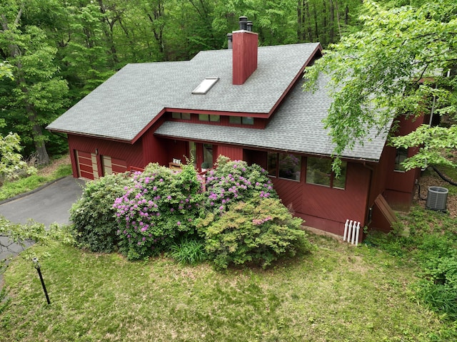 114 Mountain View Rd, Glastonbury, CT 06033 - view of front of property with a shingled roof, a chimney, central AC, and a front lawn