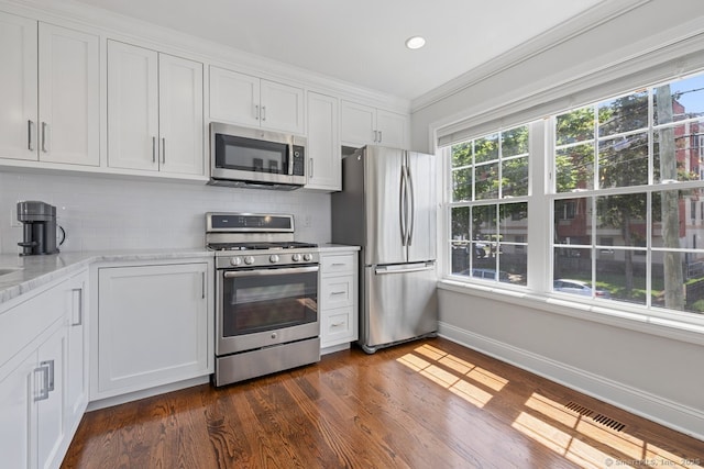 20 3rd St Unit 4, Stamford, CT 06905 - kitchen with appliances with stainless steel finishes, plenty of natural light, baseboards, white cabinetry, and crown molding