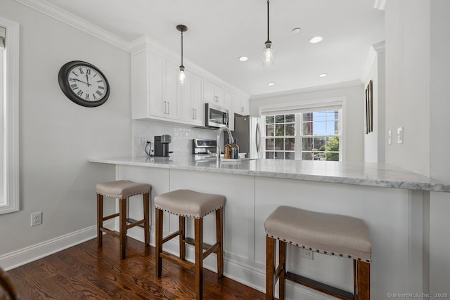 20 3rd St Unit 4, Stamford, CT 06905 - kitchen featuring stainless steel appliances, a peninsula, crown molding, tasteful backsplash, and white cabinets