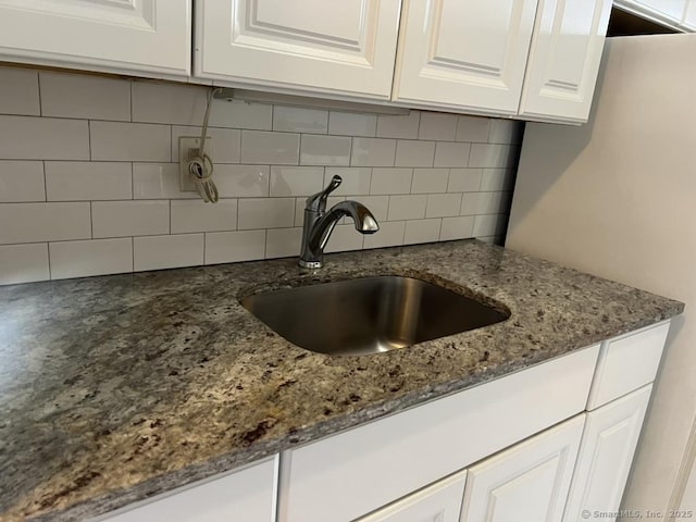 1 Walter Ave Apt 50, Norwalk, CT 06851 - kitchen view of a sink, white cabinets, decorative backsplash, and dark stone countertops