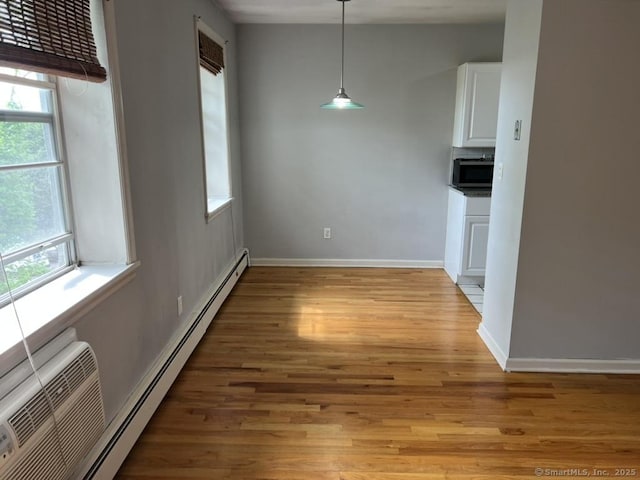 1 Walter Ave Apt 50, Norwalk, CT 06851 - unfurnished dining area with a baseboard heating unit, light wood-style flooring, and baseboards